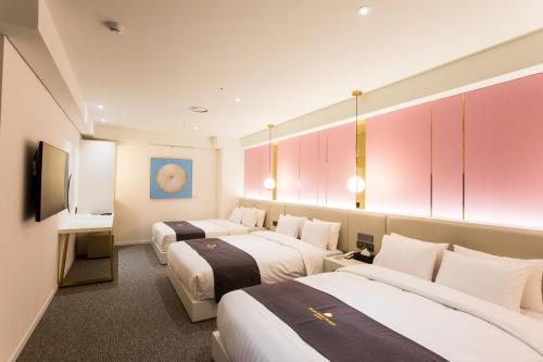 a hotel room with two beds and a tv at Interburgo Hotel Wonju in Wonju