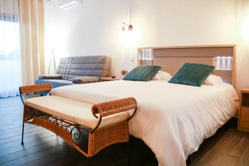 een slaapkamer met een groot wit bed en een stoel bij São Pedro Country House in Campo Maior