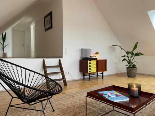 a living room with a chair and a table at Stilvolle Apartments auf dem Weingut Schätzel in Nierstein