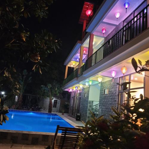 a villa with a swimming pool at night at Tam Coc Mountain Lake Homestay in Ninh Binh