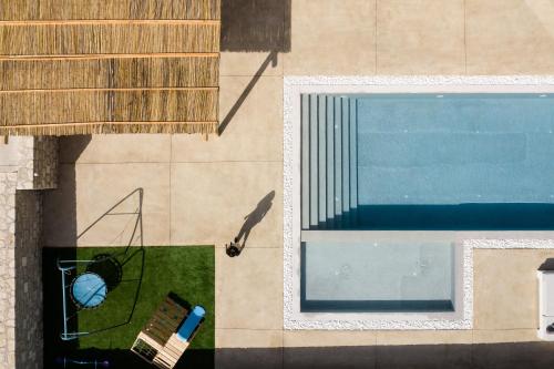 an overhead view of a swimming pool with a bench at Ayali Villa II, a divine luxury homestay, By ThinkVilla in Achlades