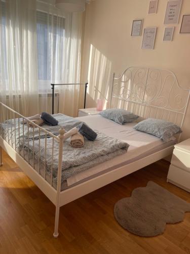 a bedroom with a white bed with a metal frame at Apartment Orchid 021 in Novi Sad