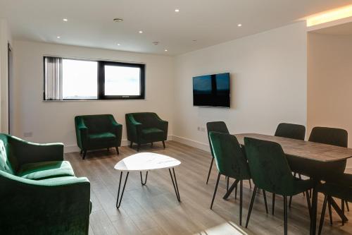 a conference room with a table and green chairs at Charles Hope London Brentford in Brentford
