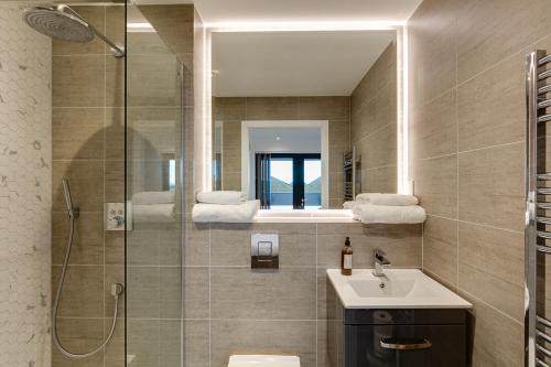 a bathroom with a shower and a sink and a mirror at Brentford Apartments by Charles Hope in Brentford