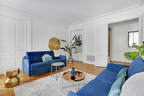 un salon avec un canapé bleu et une table dans l'établissement Classy appartment - Arc de Triomphe, à Paris