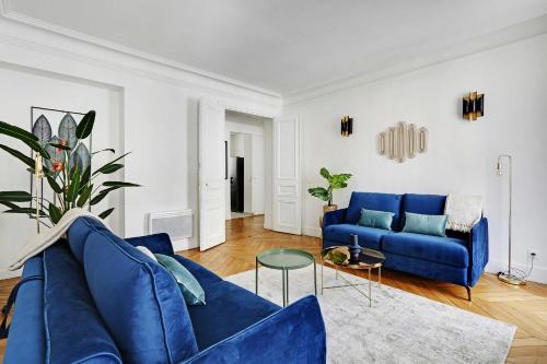 un salon avec un canapé bleu et une table dans l'établissement Classy appartment - Arc de Triomphe, à Paris