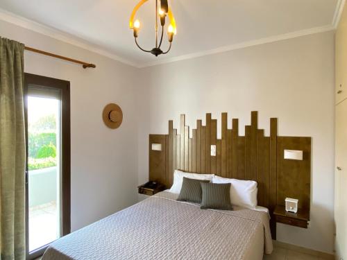 Un dormitorio con una cama grande y una lámpara de araña. en Caviro, en Moúdhros