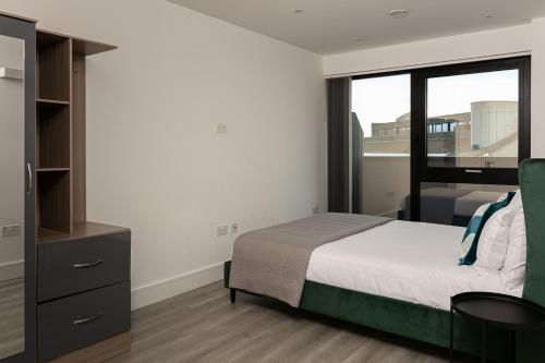 a bedroom with a bed and a large window at Charles Hope London Brentford in Brentford