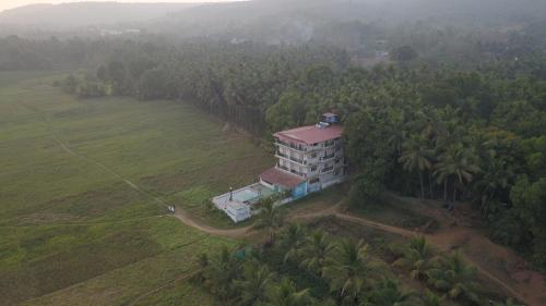 an aerial view of a building in the middle of a field at Shivam Bnb Mandrem Resort in Mandrem