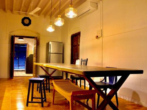 GoSolo Stays في مومباي: طاولة خشبية كبيرة في غرفة مع كراسي