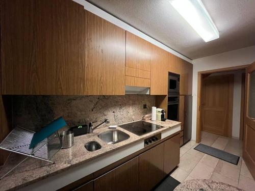 a kitchen with a sink and wooden cabinets at Specious 5.5 rooms garden house @ Wallisellen in Wallisellen