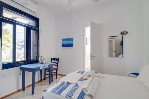 a bedroom with a bed and a desk and a window at Agriolykos Pension in Agios Kirykos