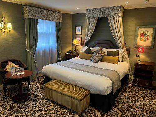 um quarto de hotel com uma cama grande e uma mesa em The Leonard Hotel em Londres