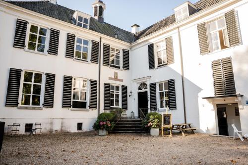 un gran edificio blanco con persianas negras en Landgoed Halsaf, en Babberich