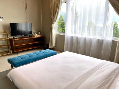 a bedroom with a bed and a tv and a window at Alinson Sunset Hill in Bogor