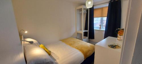 a small bedroom with a bed and a window at The Tackeroo Suite in Hednesford