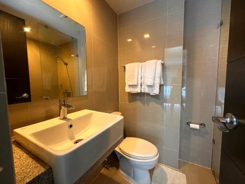 a bathroom with a sink and a toilet and a shower at Uptown BGC Luxury 1br Suite with Fast Wifi in Manila