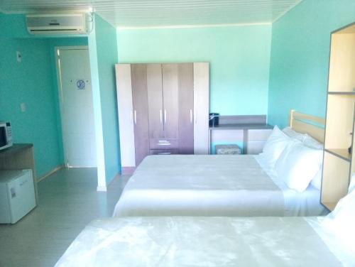 a bedroom with a large white bed in a room at Pousada Tradição in Gramado