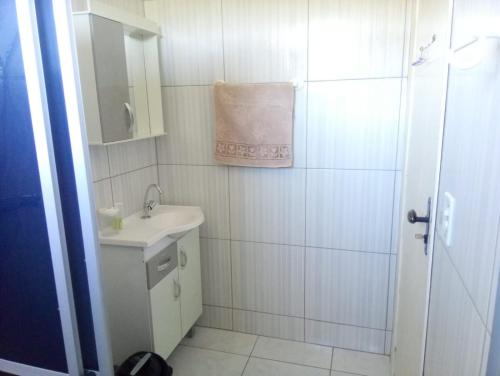uma casa de banho branca com um lavatório e um espelho em Pousada Tradição em Gramado