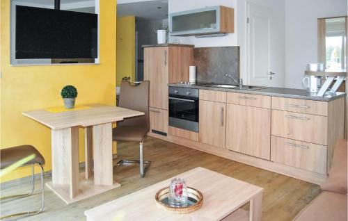a kitchen with wooden cabinets and a table in it at Fewo Burg Müggenburg in Kaschow