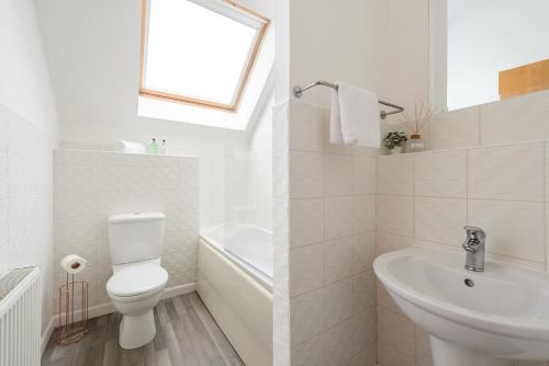 Baño blanco con aseo y lavamanos en The Modern Mill Apartment en Edimburgo
