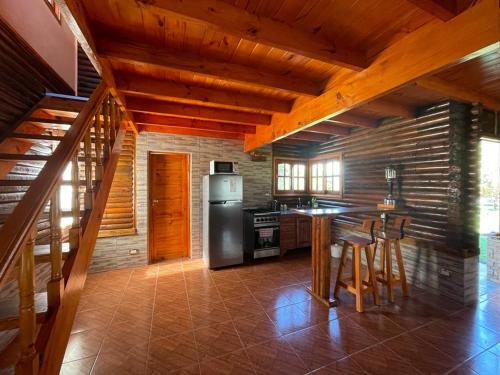 a kitchen with a stainless steel refrigerator and a table at Náutico Apart Hotel in Chascomús