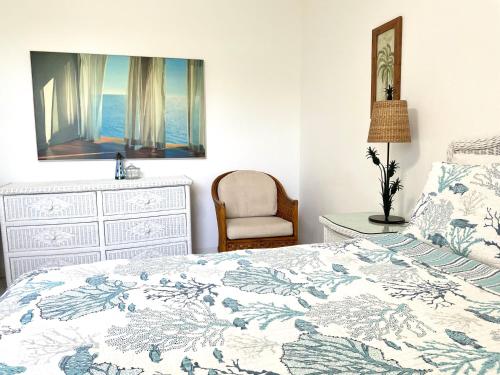 a bedroom with a bed and a dresser and a chair at Sunset Cove - Vacation In Paradise! in Nassau