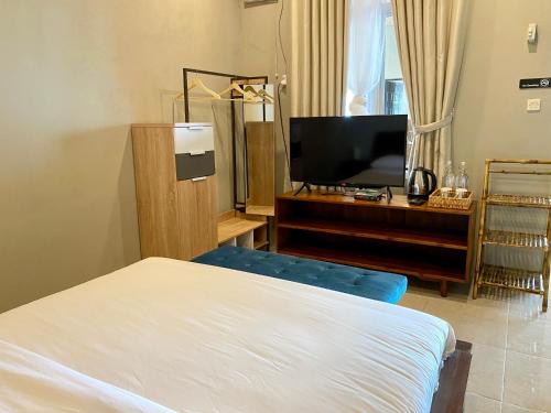 a bedroom with a bed and a flat screen tv at Alinson Sunset Hill in Bogor
