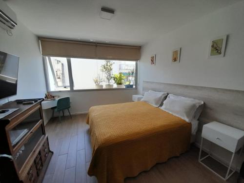 a small bedroom with a bed and a window at Recoleta Departamento in Buenos Aires