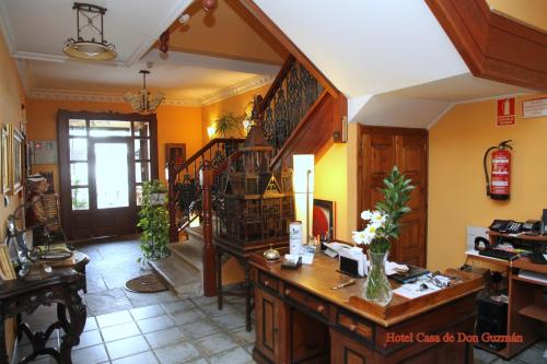 a living room with a desk and a staircase at Posada Casa de don Guzman in Vega de Pas