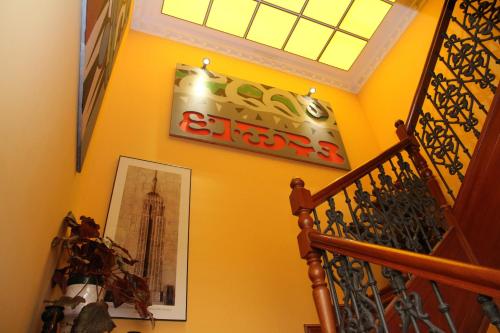 una escalera con un letrero en una pared amarilla en Posada Casa de don Guzman en Vega de Pas