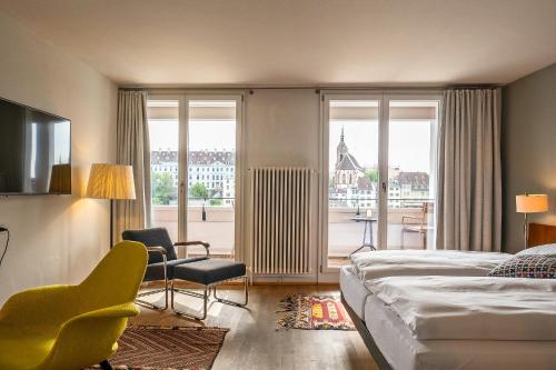 una camera d'albergo con un letto e una grande finestra di Krafft Basel a Basilea