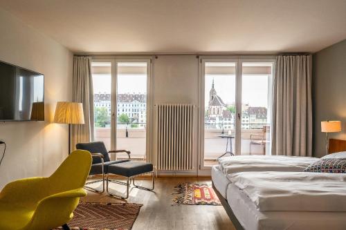 a hotel room with a bed and a large window at Krafft Basel in Basel