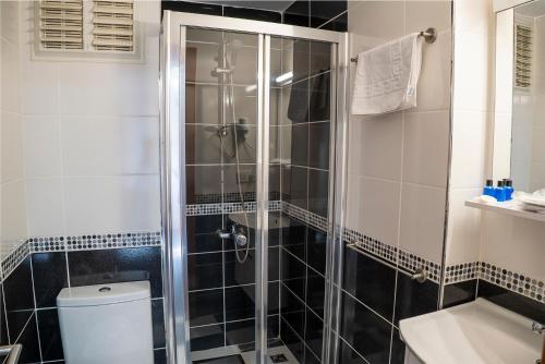 a bathroom with a shower with a toilet and a sink at My Palace Hotel in İçmeler