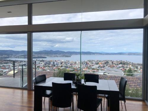 a dining room with a table and chairs and a large window at Hobart View in Hobart