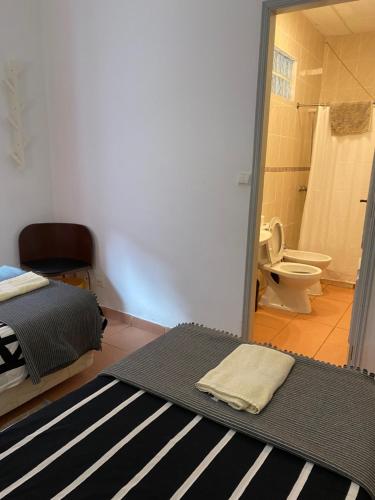 een slaapkamer met een bed en een badkamer met een toilet bij The Tiles House in Faro