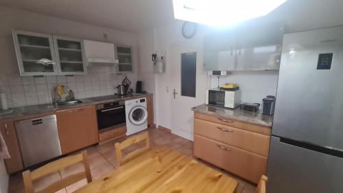 a kitchen with wooden cabinets and a white appliance at Ferienwohnung Grimmer in Weil am Rhein