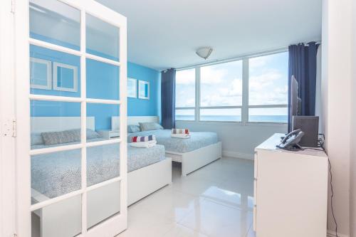 a room with two beds and a television in it at Girasole Rentals Suites in Miami Beach