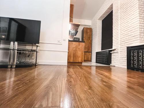 a living room with a wooden floor and a flat screen tv at Квартира на Крещатике in Kyiv