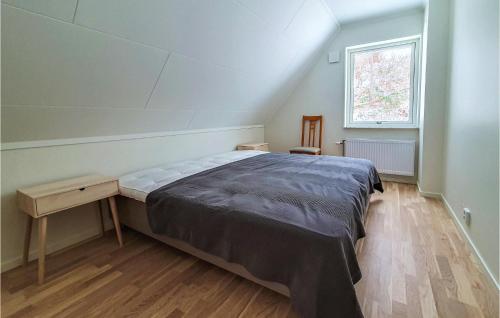 een slaapkamer met een bed, een tafel en een raam bij Stunning Home In Bstad With Wifi in Båstad
