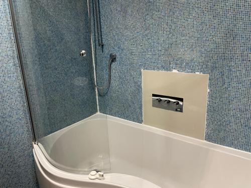 a bathroom with a shower with a tub and a toilet at Gated Community Modern & Stylish House with Parking in London
