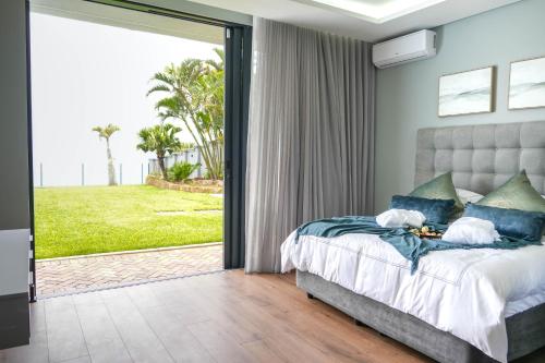 a bedroom with a bed and a large sliding glass door at 253 on Ipahla in Amanzimtoti