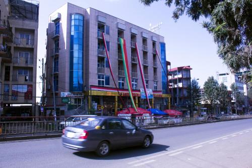 a car driving down a street in front of a building at Aselefech Merga Hotel and Spa in Addis Ababa