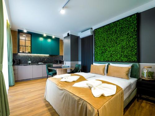 Un dormitorio con una cama grande y una pared verde en Aparthotel Green Concrete - nowy, ekologiczny hotel w Świnoujściu, en Świnoujście