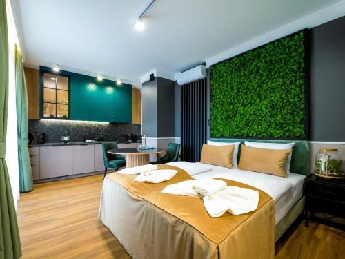 a bedroom with a large bed and a green wall at Aparthotel Green Concrete - nowy, ekologiczny hotel w Świnoujściu in Świnoujście