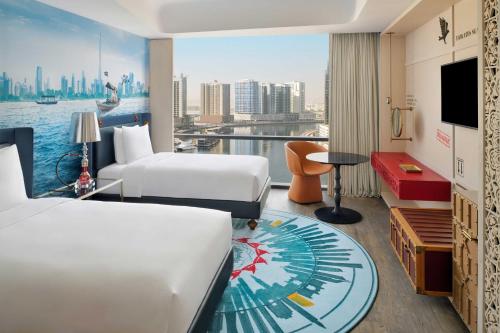 Hotel Indigo Dubai Downtown, an IHG Hotel في دبي: غرفة فندقية بسريرين وإطلالة على المدينة