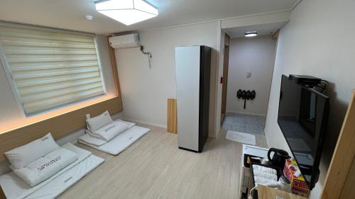 a room with white pillows and a flat screen tv at Tongyeong Chosun Hotel in Tongyeong