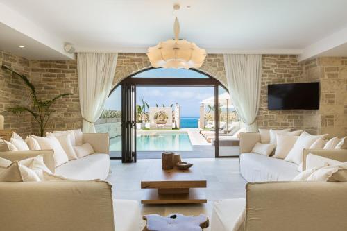 sala de estar con muebles blancos y piscina en Villa Moana, en Balíon
