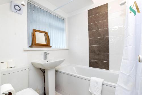 ein weißes Badezimmer mit einem Waschbecken und einer Badewanne in der Unterkunft Wroxton Close TSAC in Middlesbrough