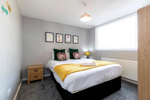 a bedroom with a large bed with a yellow blanket at Wroxton Close TSAC in Middlesbrough